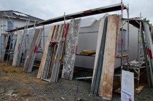 Um das Haus herum aufgestellte Gerüstteile