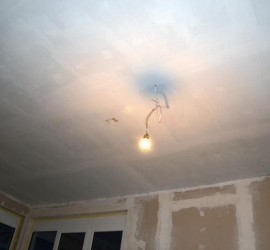 Wohnzimmer-Decke mit Sperrgrund grundiert