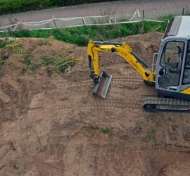 Bagger beim Planieren des Gartens