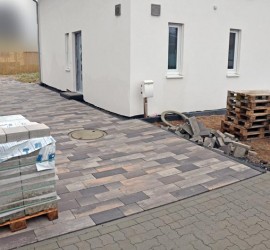 Die fertig gepflasterte Einfahrt mit nassen Pflastersteinen