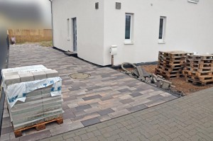 Die fertig gepflasterte Einfahrt mit nassen Pflastersteinen