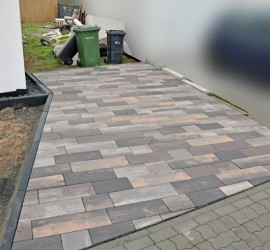 Der gepflasterte Stellplatz mit nassen Pflastersteinen