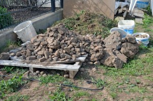 Aus dem Erdreich befreite Steine und Grünzeugs