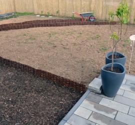 Terrassenblick auf Gartenwege mit Weidenbegrenzung