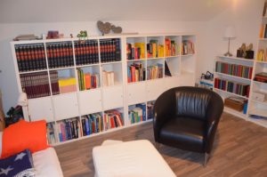 Kallax-Regale fertig eingeräumt, davor Lese-Sessel und Höckerchen